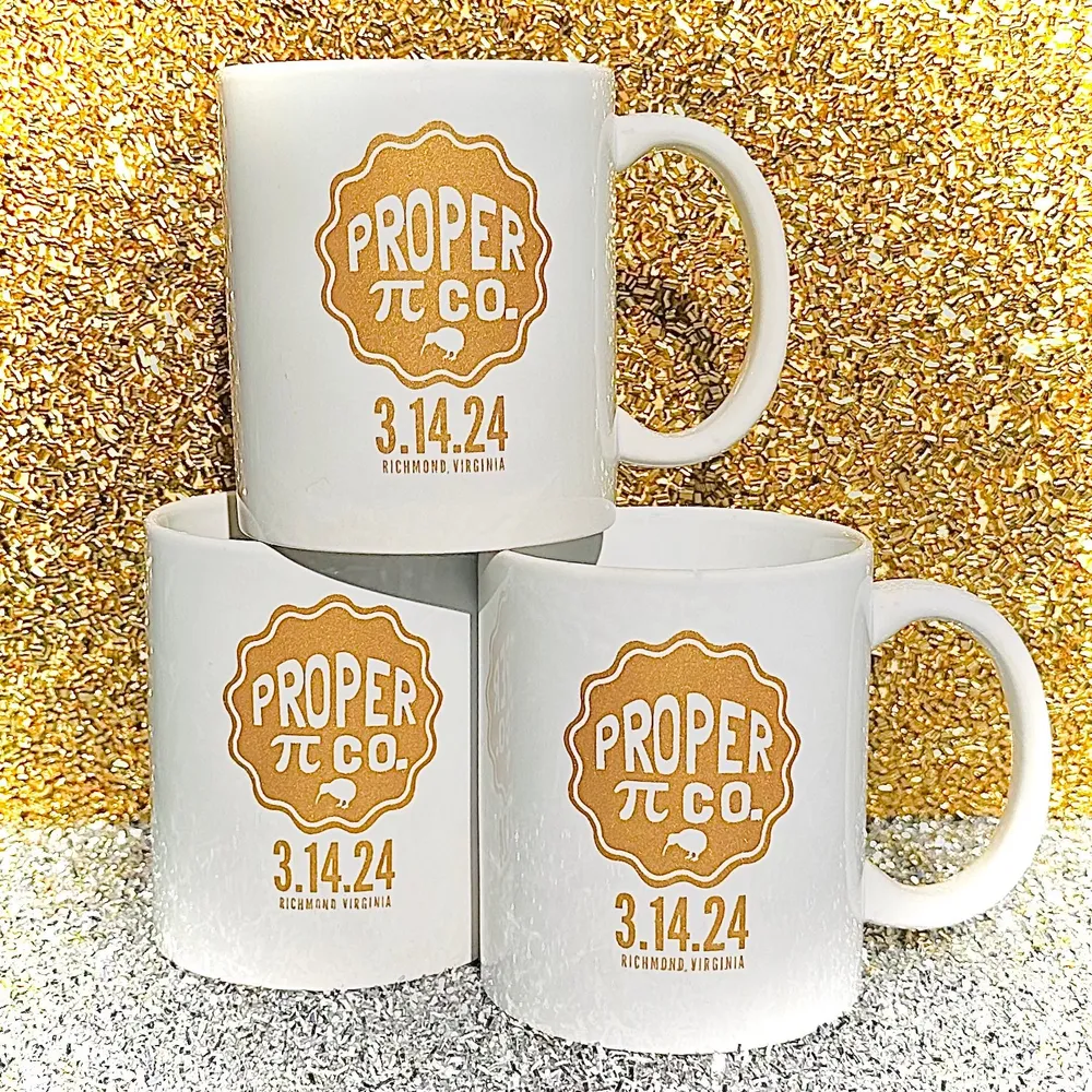 Three white Proper Pie Pi Day mugs stamped 3.14.24, stacked against gold glitter