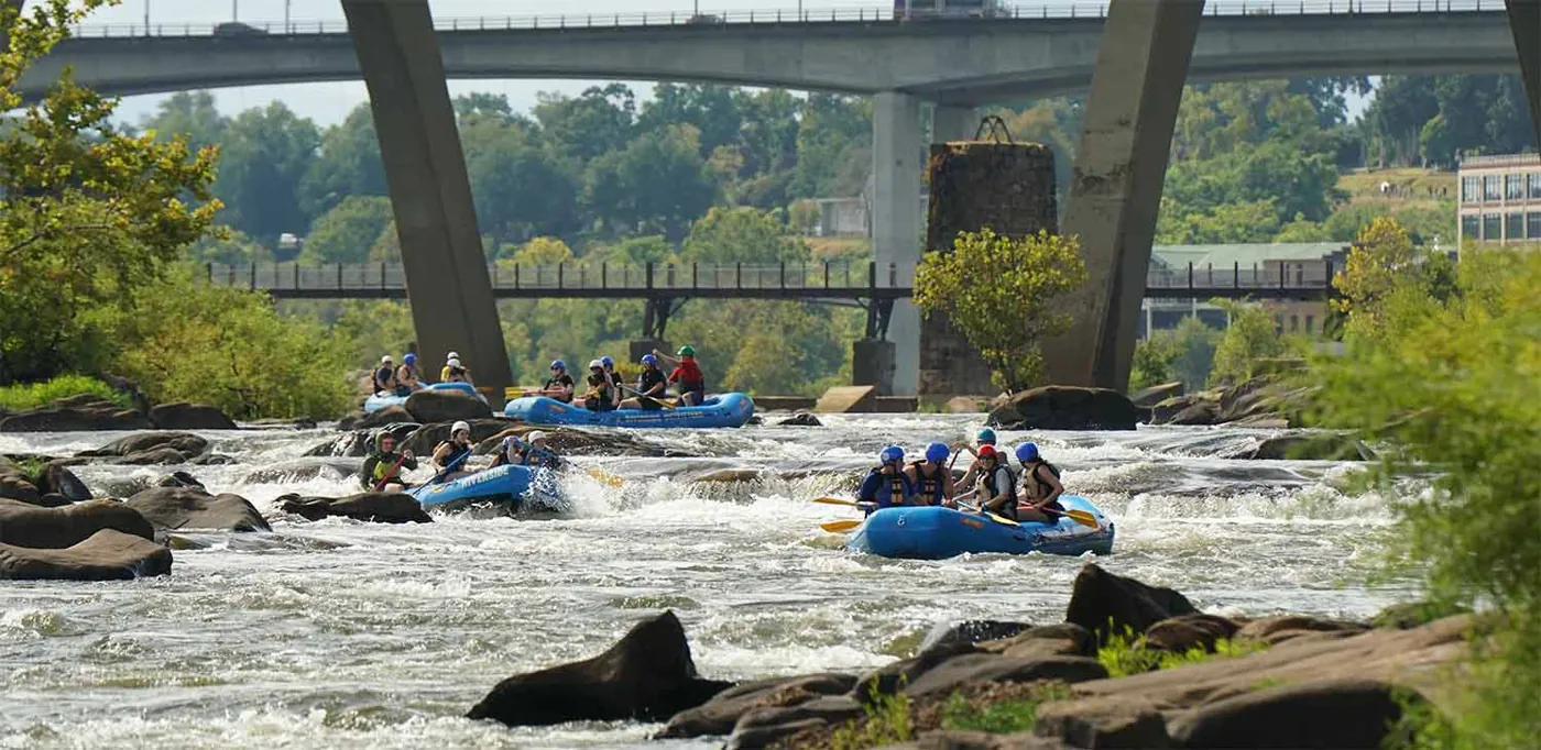 Rafts on the James running a rapid under the downtown Richmond bridges