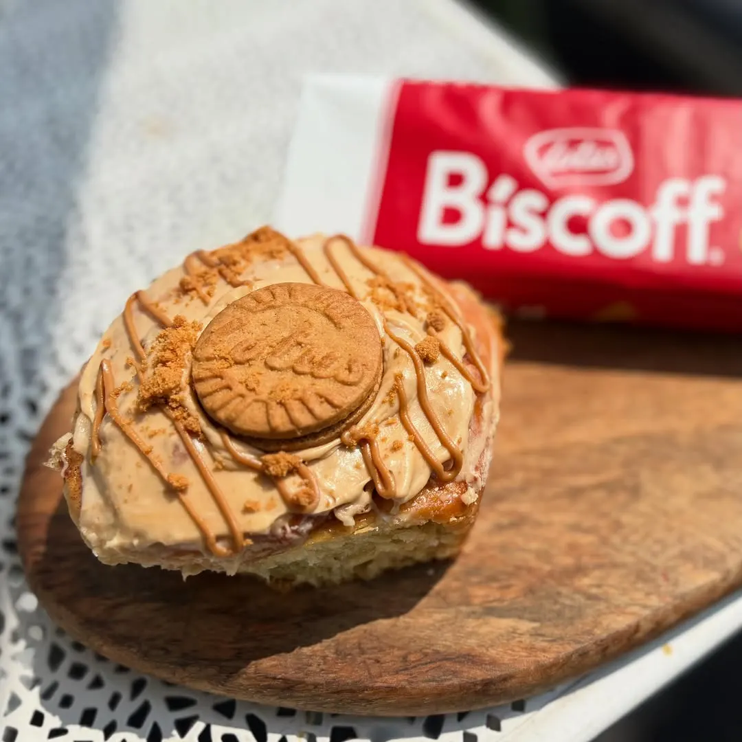 A dessert square topped with a Biscoff cookie and caramel drizzle, beside a Biscoff packet