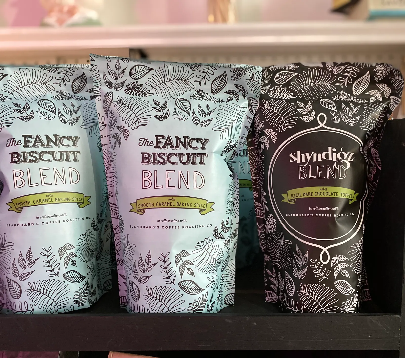 Bags of The Fancy Biscuit Blend and Shyndigz Blend coffee on a shelf