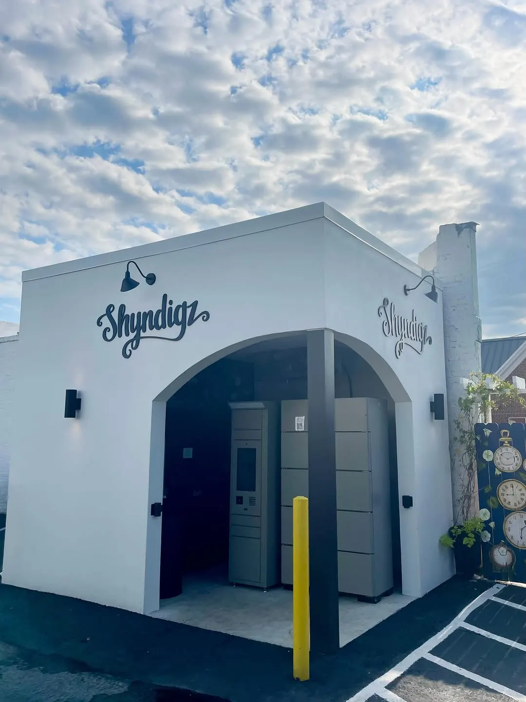 The white arched Shyndigz locker house in the parking lot, with a wall of refrigerated lockers and a payment screen inside